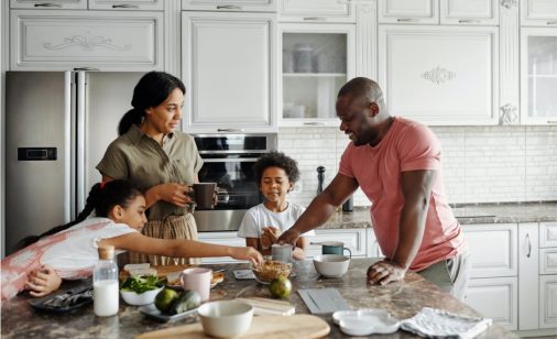 Une famille prépare des aliments sur un comptoir de cuisine