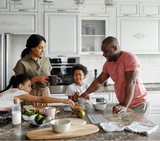 Une famille prépare des aliments sur un comptoir de cuisine