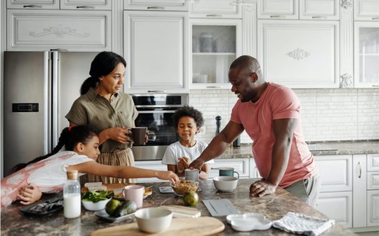 Une famille prépare des aliments sur un comptoir de cuisine