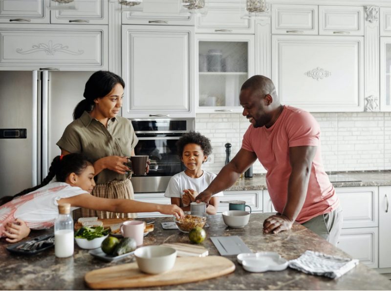 Une famille prépare des aliments sur un comptoir de cuisine