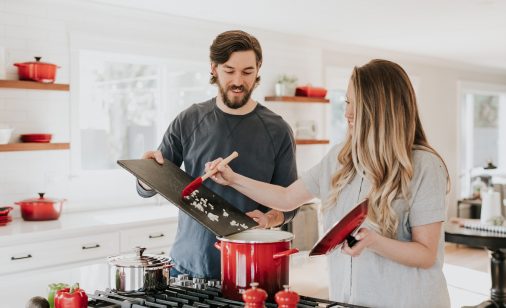 A man and woman cooking on a stovetop