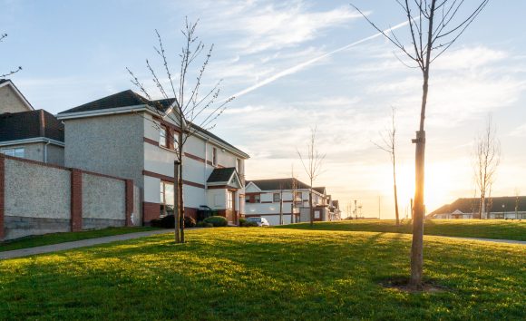 Side view of houses and grass in a neighbourhood after sunset