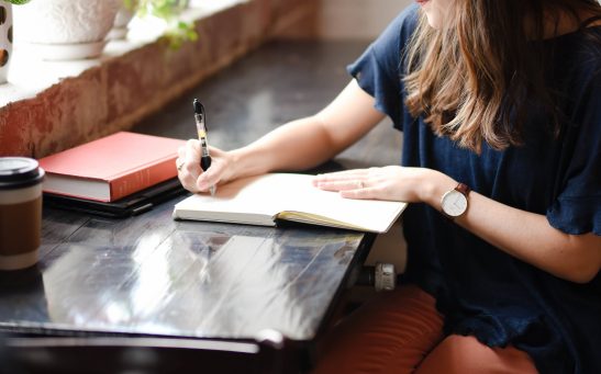 A woman writing notes in a notebook