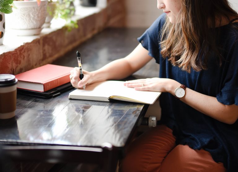 Une femme qui écrit des notes dans un carnet