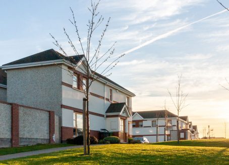 Vue de côté de maisons et de pelouses dans un quartier après le coucher du soleil