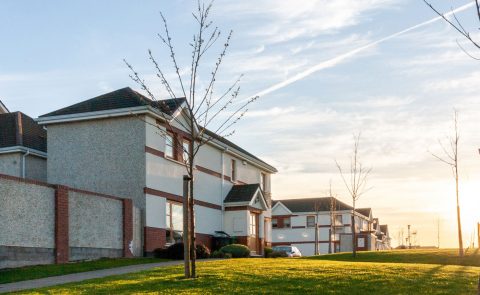 Vue de côté de maisons et de pelouses dans un quartier après le coucher du soleil