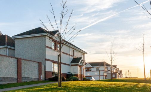 Vue de côté de maisons et de pelouses dans un quartier après le coucher du soleil