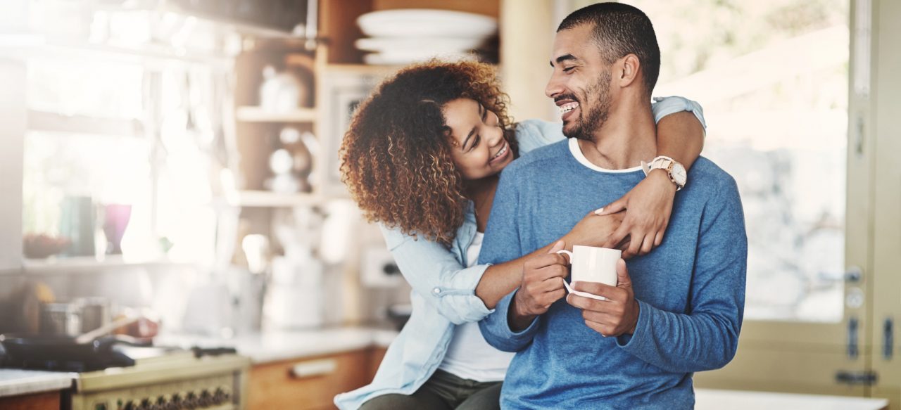 A woman hugging a man in a kitchen