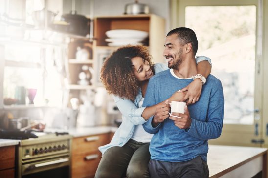 A woman hugging a man in a kitchen