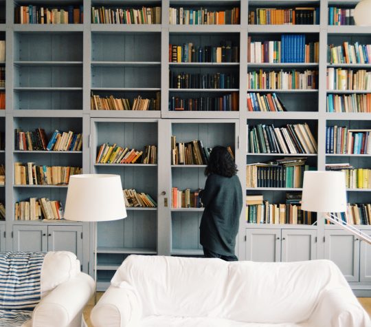 Back view of a woman looking at bookshelves