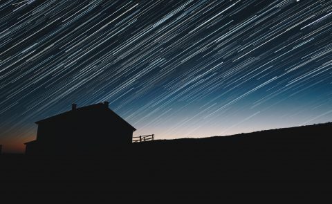 A silhouette of a home in a dark sky