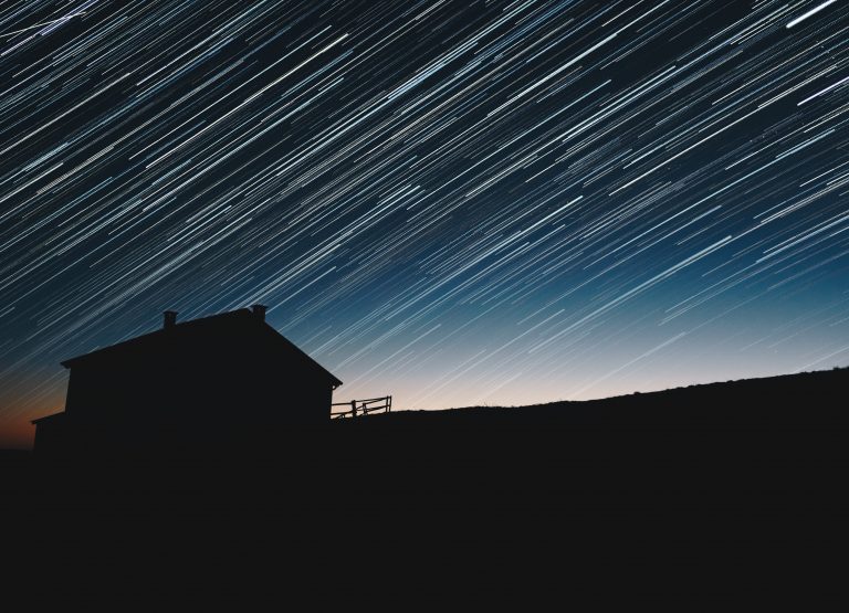 A silhouette of a home in a dark sky