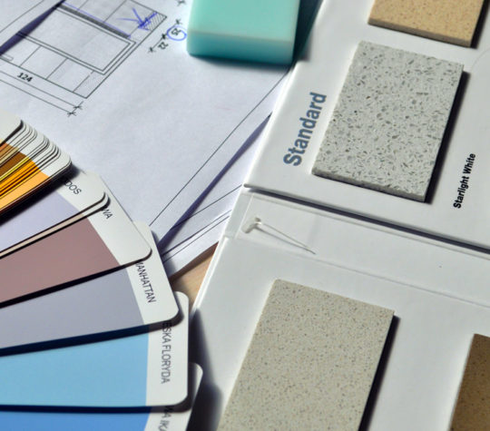 Paint and countertop swatches spread out on a table