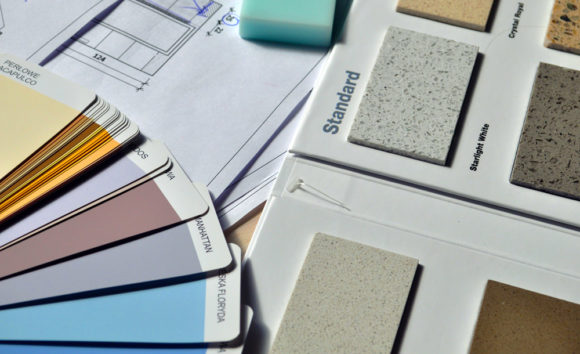 Paint and countertop swatches spread out on a table